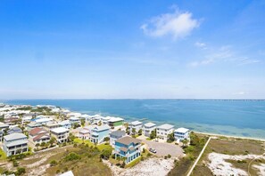Un área residencial costera con casas, una playa y el océano.