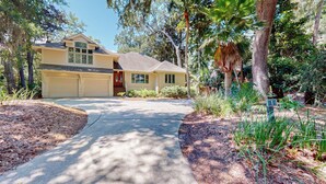 A two-story house with a garage, a front porch, and a driveway leading to the entrance.