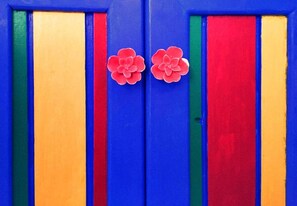 Une porte ornée de rayures verticales bleues, rouges, vertes et jaunes.