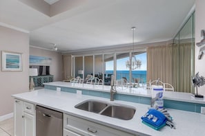 Enjoy ocean views from the kitchen's large window and balcony with outdoor seating.