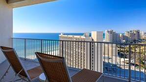 A balcony with two chairs facing a city view and the ocean. - Penthouse Unit- Large Private Beach! (Miramar Beach)