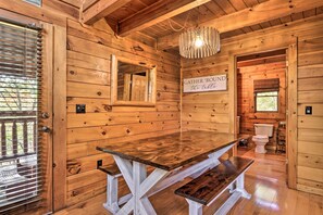 Gather 'round the table in this cozy dining area with a wooden table and benches.