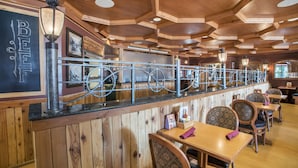 A restaurant interior with wooden paneling, a bar area, and multiple tables and chairs. - Family Getaway~Pool, Tubing, Skiing, & Ice Castles Villa 1063 (Midway)
