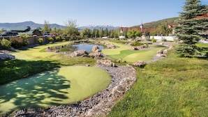 A golf course with multiple green areas, a pond, and surrounding landscaping. - Family Getaway~Pool, Tubing, Skiing, & Ice Castles Villa 1063 (Midway)
