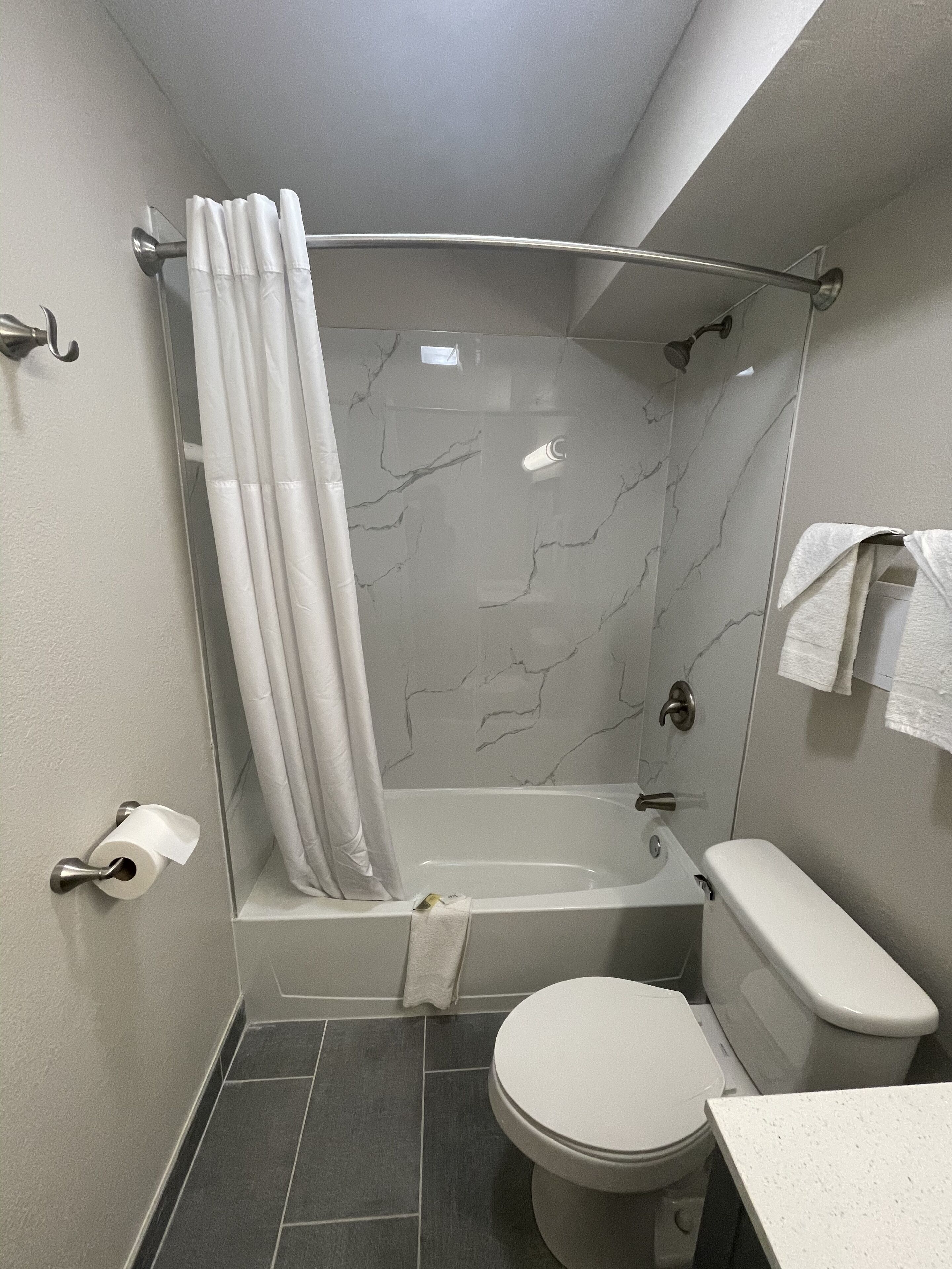 A modern bathroom with a glass-enclosed shower, a toilet, and a sink.