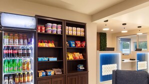 A vending machine stocked with beverages and snacks, a seating area, and a reception desk. - Baymont by Wyndham Dothan (Dothan)