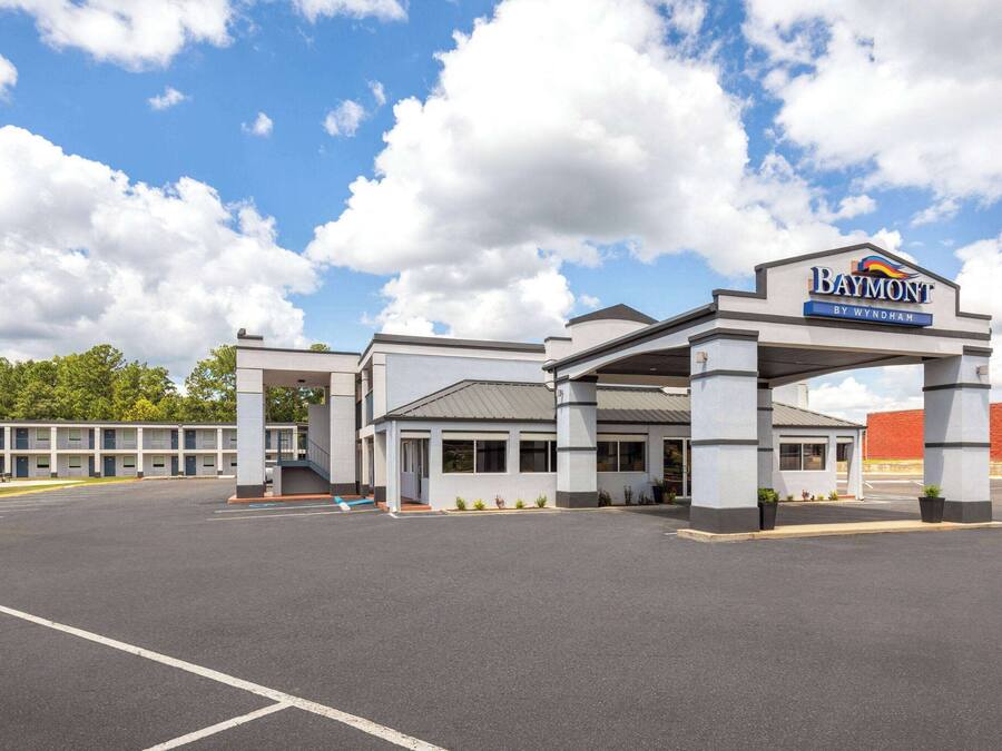 Hotel Baymont by Wyndham con estacionamiento y entrada al edificio.