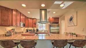 A modern kitchen with granite countertops, stainless steel appliances, and wooden cabinets. - Updated Palm Desert Escape w/ Resort Amenities! (Palm Desert)