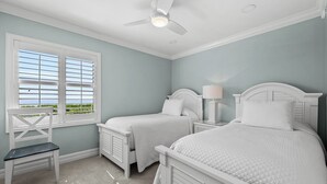 A bedroom with two beds, a desk, and a chair. - Cozy Beachfront 3 bed, 2 bath at Sanibel Moorings #522 (Sanibel)