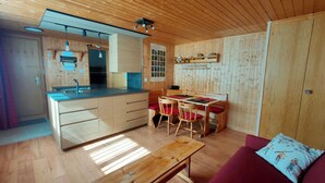 Ambiente in legno con cucina, sala da pranzo e divano.