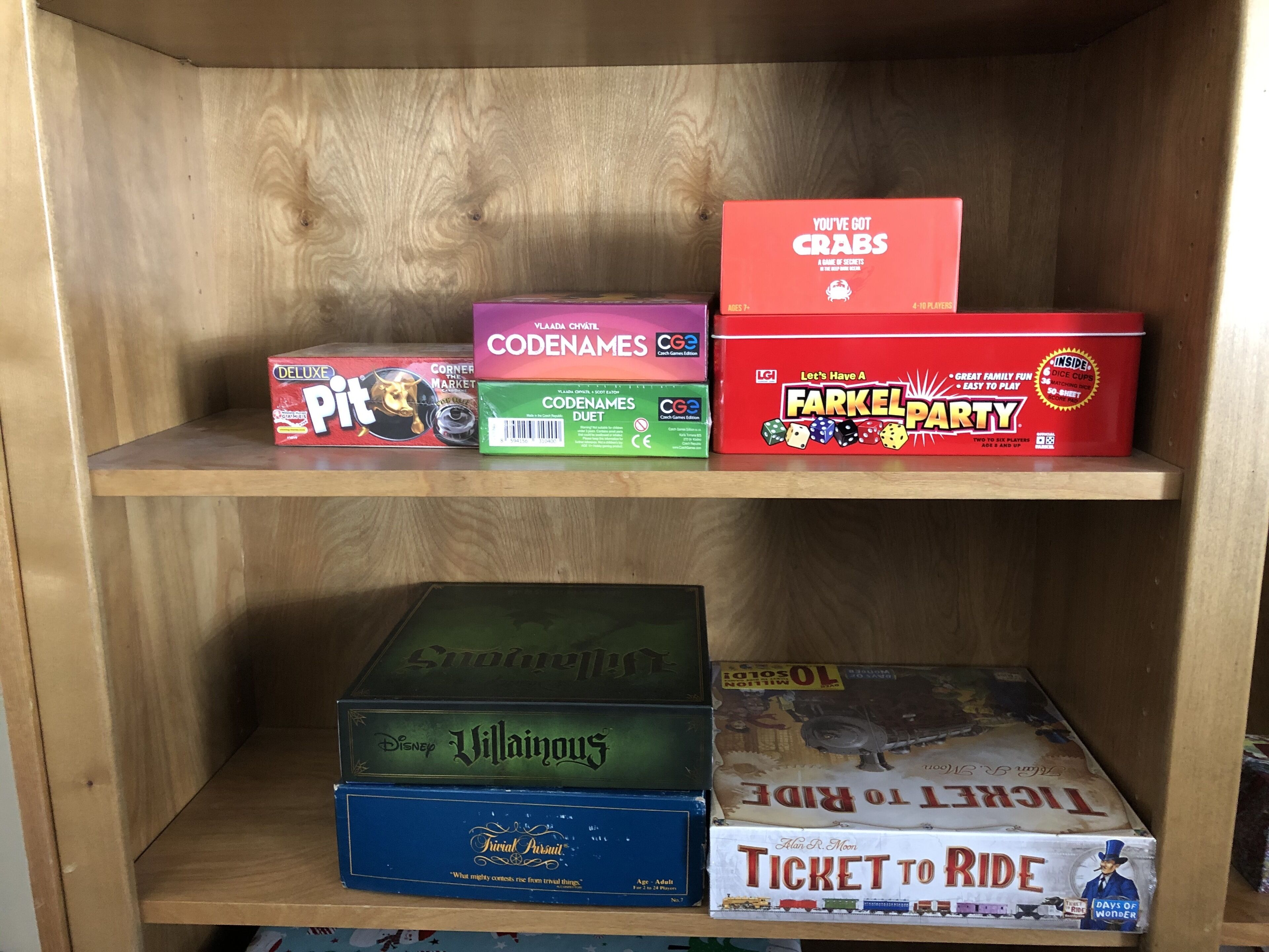 A wooden shelf with various board games.