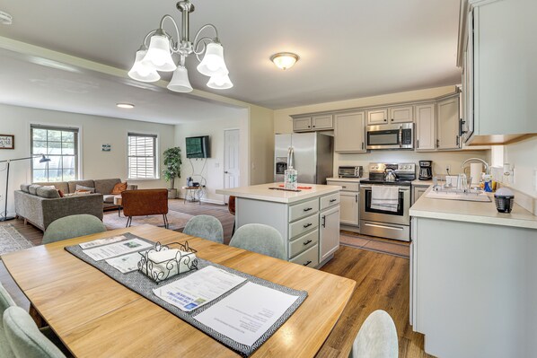 Een moderne keuken met witte kasten, roestvrijstalen apparatuur en een centraal eiland.