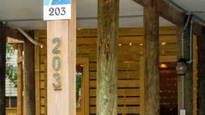 Eine hölzerne Konstruktion mit einem Schild, das Raum Nummer 203 anzeigt.