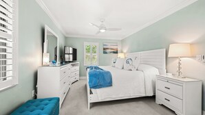 A bedroom with a bed, a dresser, a television, a ceiling fan, and a window with blinds. - Cozy Dockside 2 bed, 2 bath at Sanibel Moorings #1422 (Sanibel)