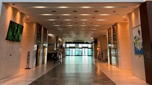 A spacious, modern lobby with a high ceiling, marble flooring, and a view of the sky through large windows. - Beache Palace (Boryeong)