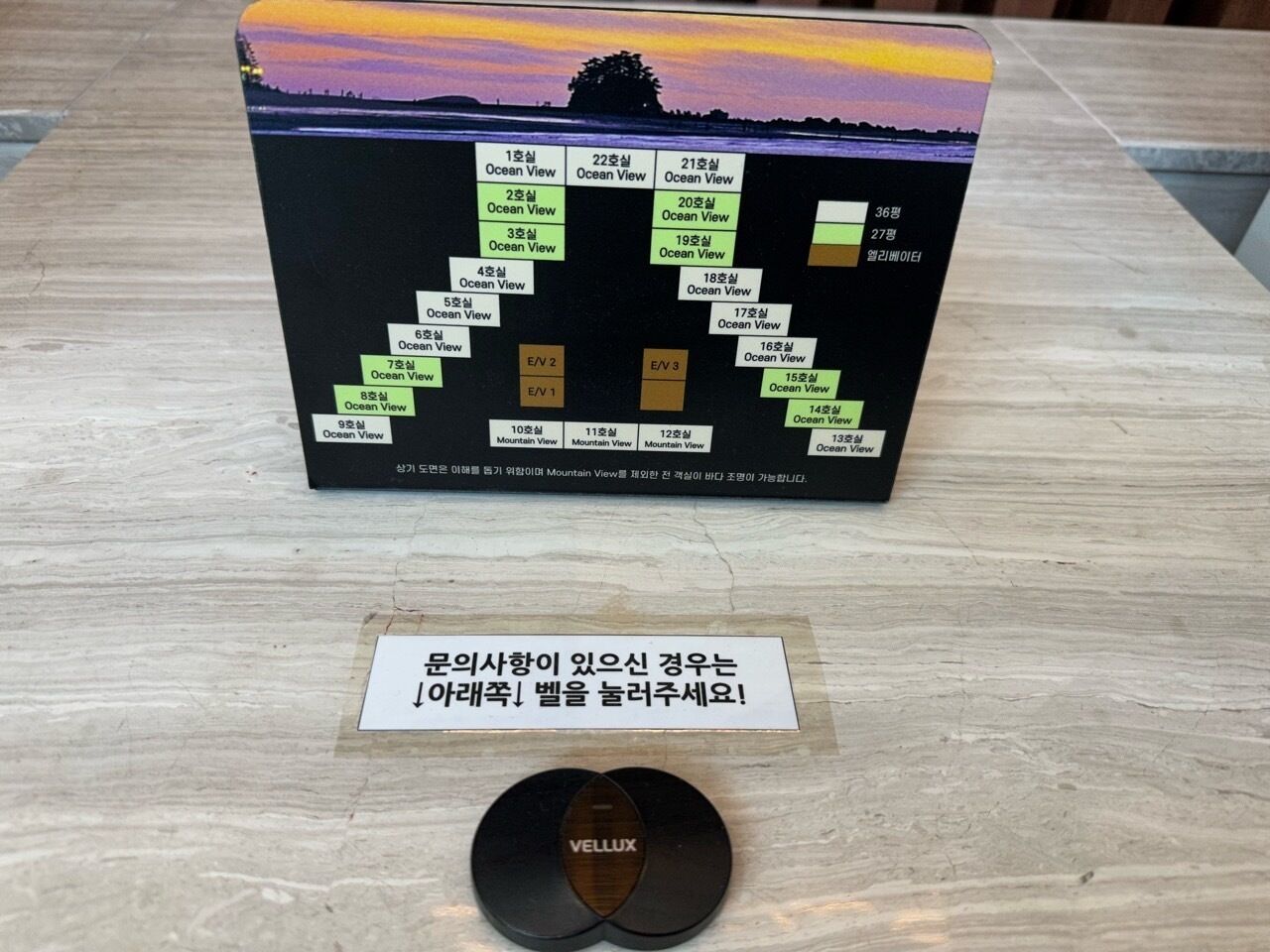 A travel itinerary board with various ocean and mountain views listed, a VELUX mouse pad, and a Korean sign.
