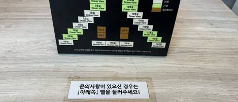 A travel itinerary board with various ocean and mountain views listed, a VELUX mouse pad, and a Korean sign.