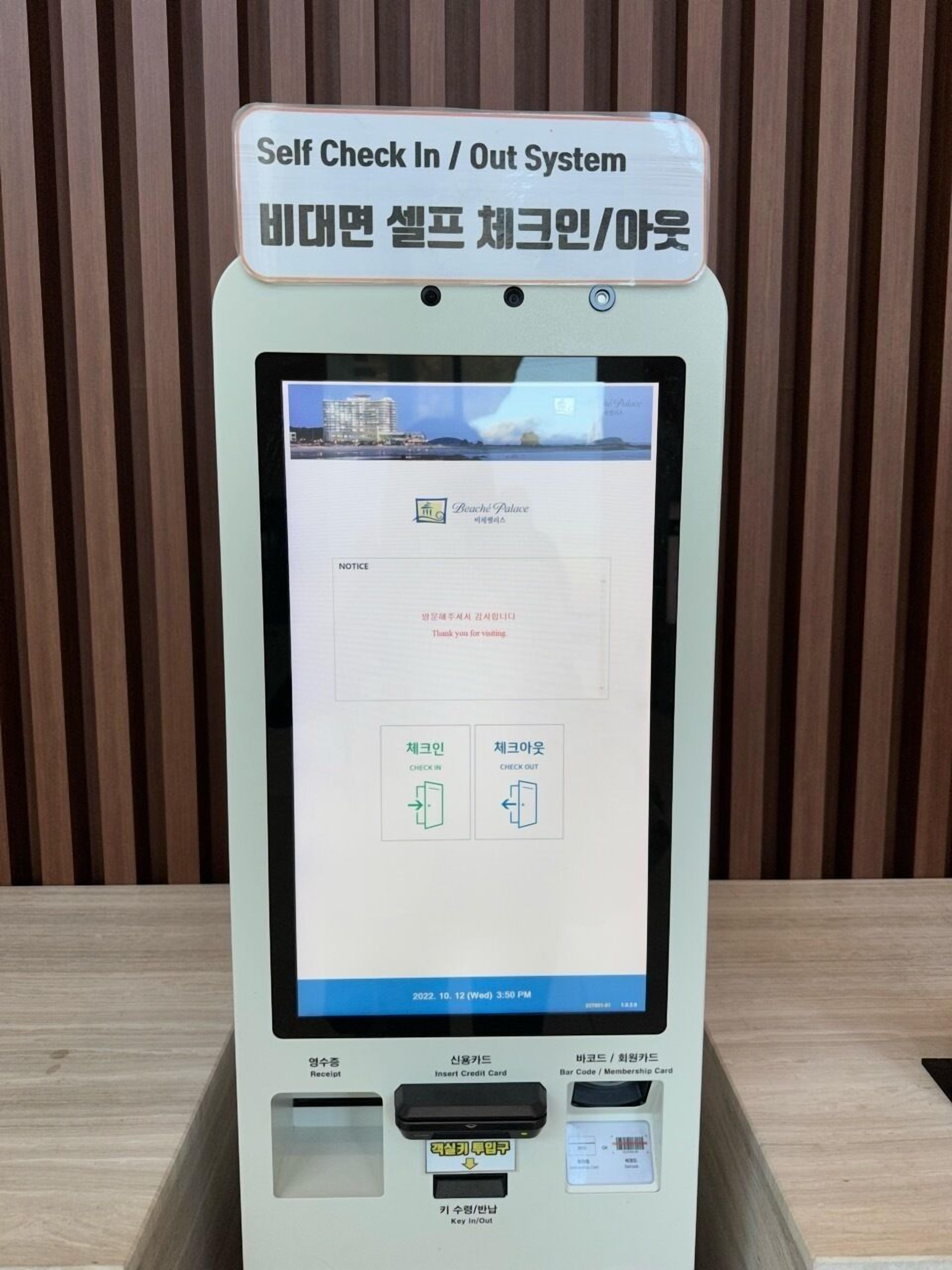 A self-check-in/out system kiosk with a receipt printer, credit card slot, and barcode/membership card reader.