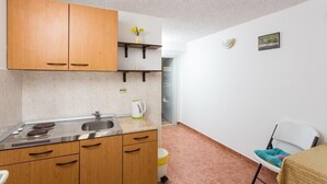 Une cuisine compacte avec des meubles en bois, un évier et une bouilloire.