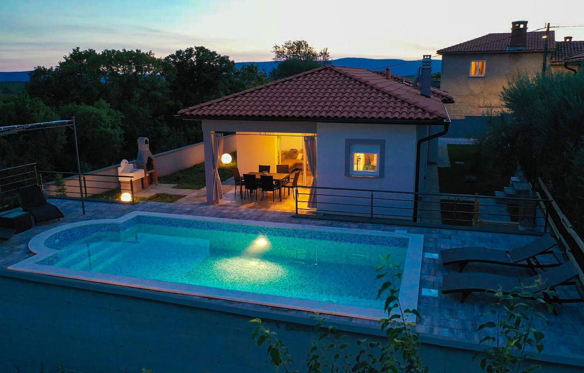 Ett hus med en swimmingpool, utomhusmöbler och en uteplats.