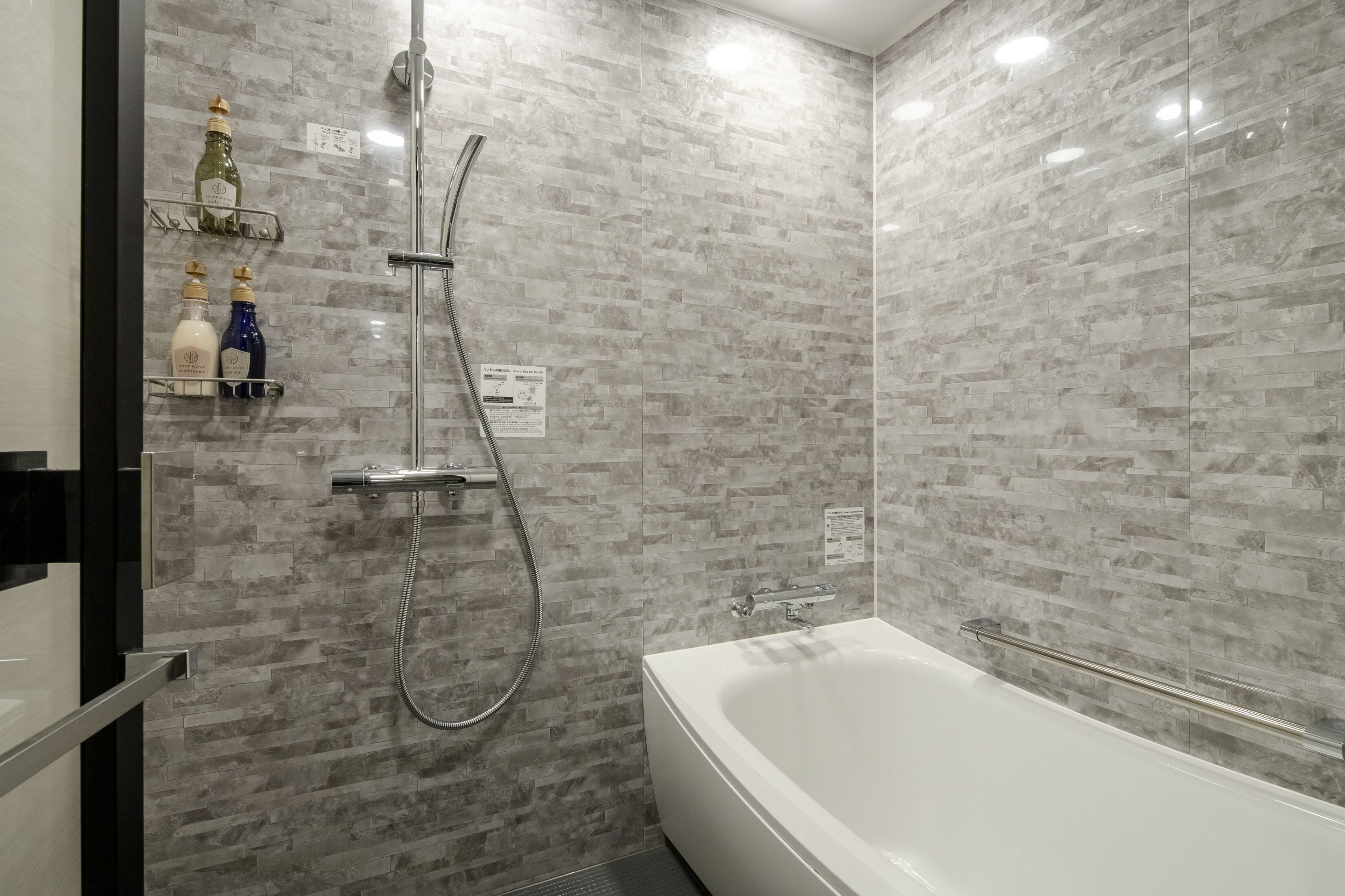 Une salle de bain moderne avec une baignoire sur pieds, une douche à parois de verre et une étagère contenant des articles de toilette.