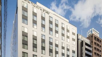 Ein modernes Hotelgebäude mit mehreren Etagen und großen Fenstern.