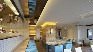 A modern hotel lobby with a long reception desk, seating areas, and a stone accent wall. - Far East Village Hotel Yokohama (Yokohama)
