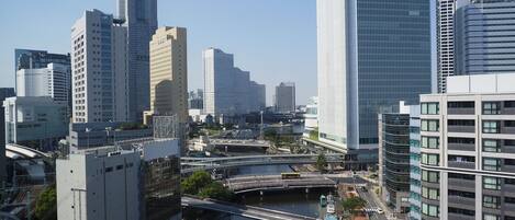 A cityscape with modern high-rise buildings, a river, and a bridge.