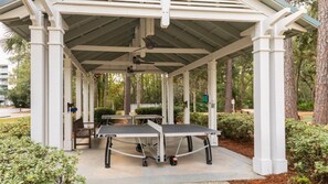 Un pavillon abrité, doté d’une table de ping-pong, entouré de verdure et d’arbres.