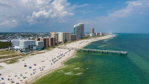 A coastal cityscape with a beach, a pier, and high-rise buildings. - Wraparound Balcony provides Gorgeous Gulf Views from Every Room (Orange Beach)