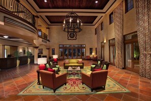 A spacious lobby with a high ceiling, a central seating area with sofas and armchairs, a reception desk, and a large chandelier. - Orlando | Orlando Family Escape | Pool & Splash Pad | 3BR Sleeps 12 (Orlando)