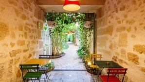 A narrow stone corridor with benches and a hanging light fixture.