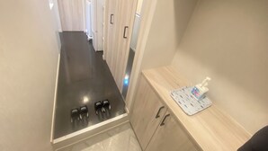 A narrow hallway with a built-in stove and a small countertop with a tissue box. - Eternity APARTMENT HOTEL SHINAGAWA (Tokyo)