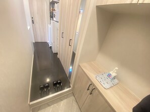 A narrow hallway with a built-in stove and a small countertop with a tissue box. - Eternity APARTMENT HOTEL SHINAGAWA (Tokyo)