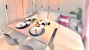 A compact living space with a dining area, sofa, and storage cabinets. - Eternity APARTMENT HOTEL SHINAGAWA (Tokyo)