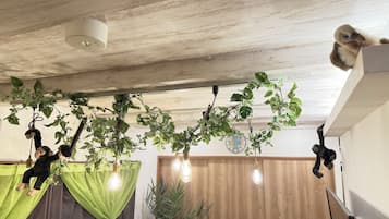 Quarto com teto de madeira, plantas penduradas e um relógio na parede.