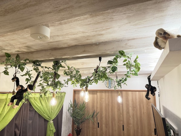 Una habitación con techo de madera, plantas colgantes y un reloj en la pared.