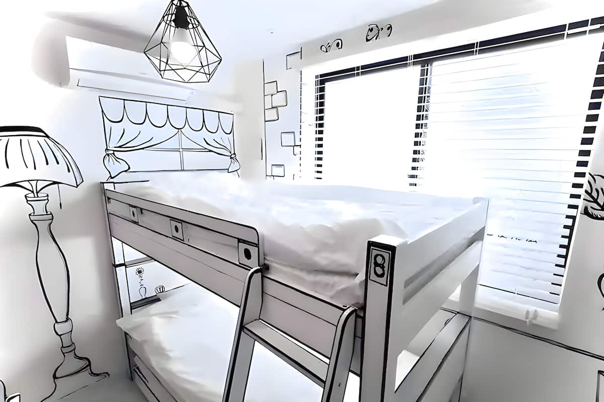 A bunk bed room with a window, a lamp, and a wall-mounted shelf.