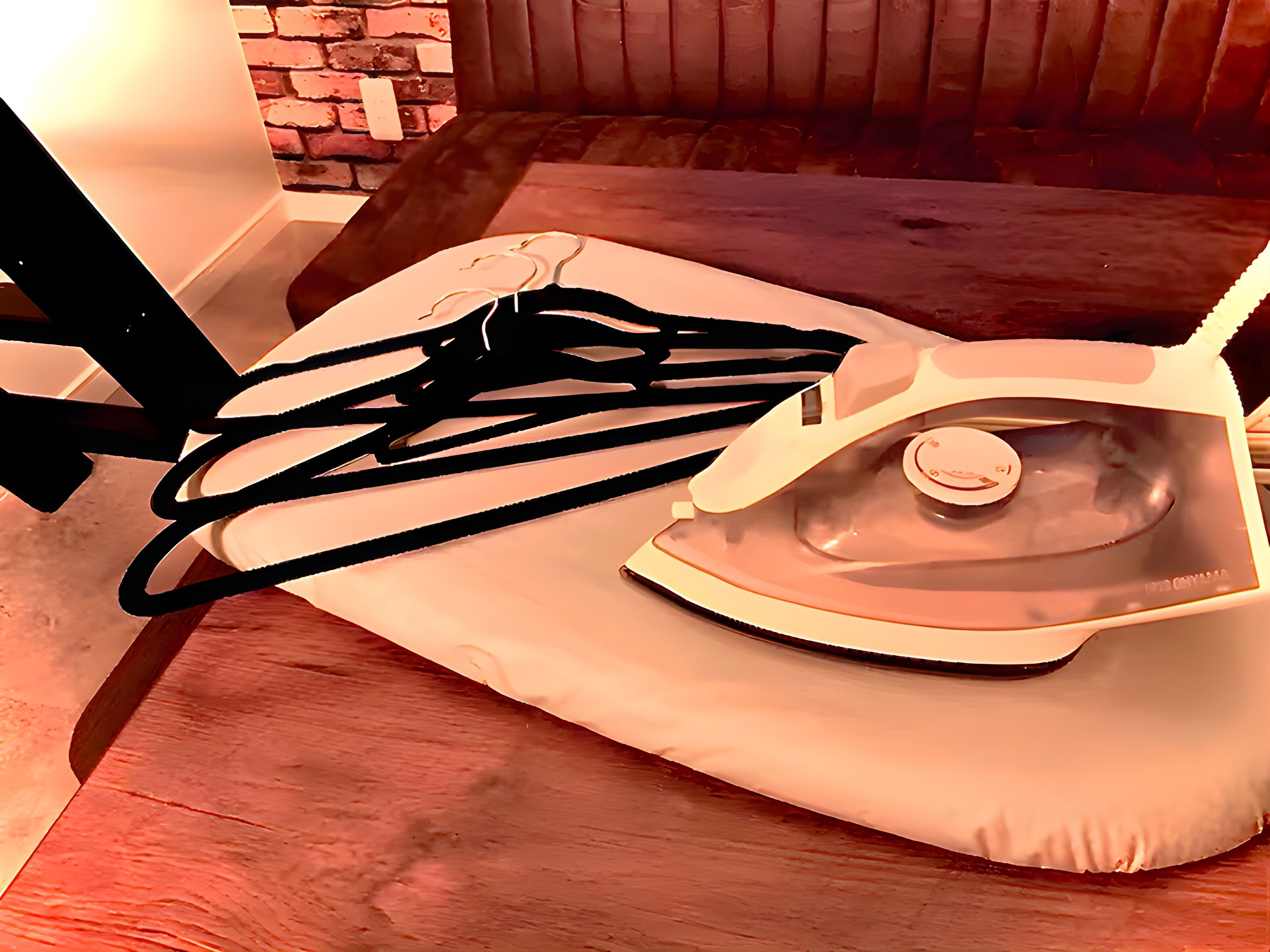 A wooden table with an iron and a black cord.