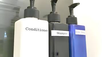 Kolme pulloa, joissa on etiketit: hoitoaine, shampoo ja vartalosaippua.
