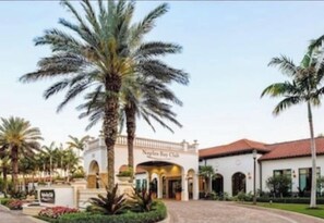 A building with a sign reading 'Nayler's Key Club,' surrounded by palm trees and a paved entrance.