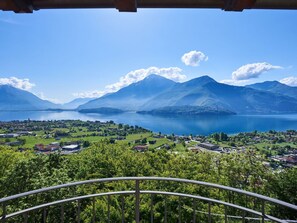 Uma varanda com vista para um lago e montanhas.
