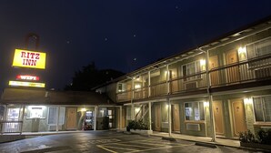 A motel with a sign for Ritz Inn, a parking lot, and a building with multiple rooms and balconies. - Ritz Inn San Francisco SFO Airport (San Bruno)