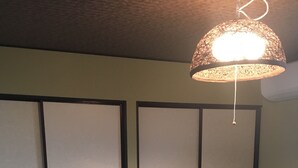 A room with tatami mats, a shoji screen door, and a hanging lamp. - Kanon House (Kyoto)