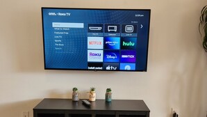Un téléviseur à écran plat fixé au mur affiche l’interface d’un service de diffusion en continu, avec différentes options telles que Netflix, Hulu et Disney+.