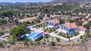 A residential area with modern houses, a swimming pool, and surrounding greenery. - Piccolo Paradiso Villa A (Lachania)