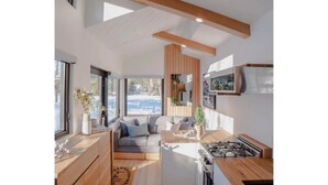 Eine moderne Küche mit Einbauherd, Holzschränken und einem großen Fenster.