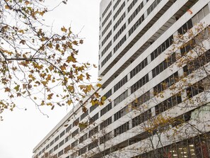 Edifício de vários andares com design arquitetônico moderno, destacando uma grade de janelas e sacadas.