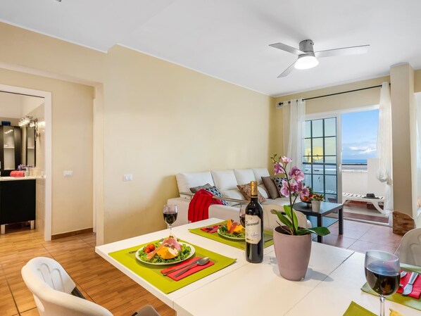 A dining area with a table set for two, a bottle of wine, and a potted plant. - C103 big terrace, pool! (San Eugenio Alto)