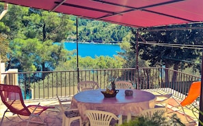 Enjoy a serene lake view from this balcony, surrounded by lush forest.